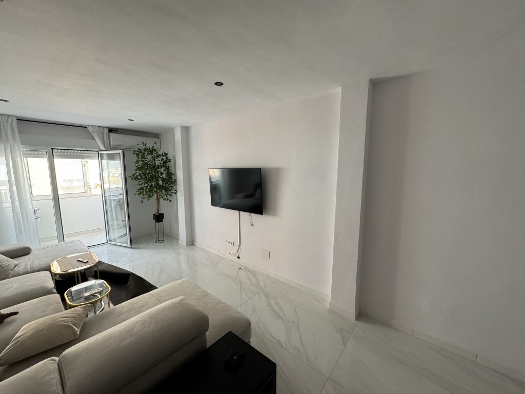 Salón moderno antes de la reforma de pared de TV con sofá beige y suelos de mármol