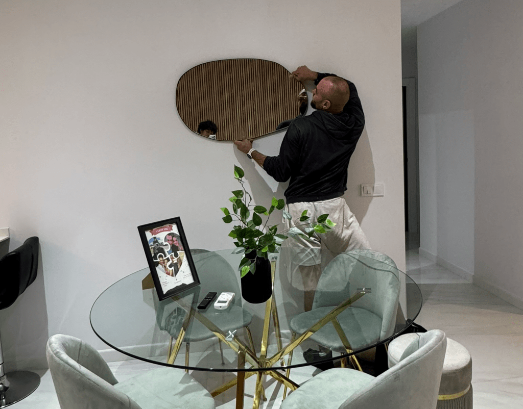 Instalación de espejo decorativo en comedor moderno con mesa redonda de cristal