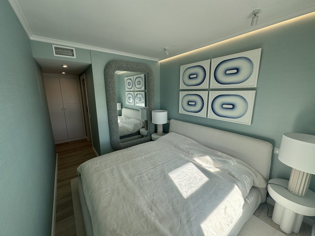 Dormitorio moderno en tonos azules con cama doble y espejo decorativo
