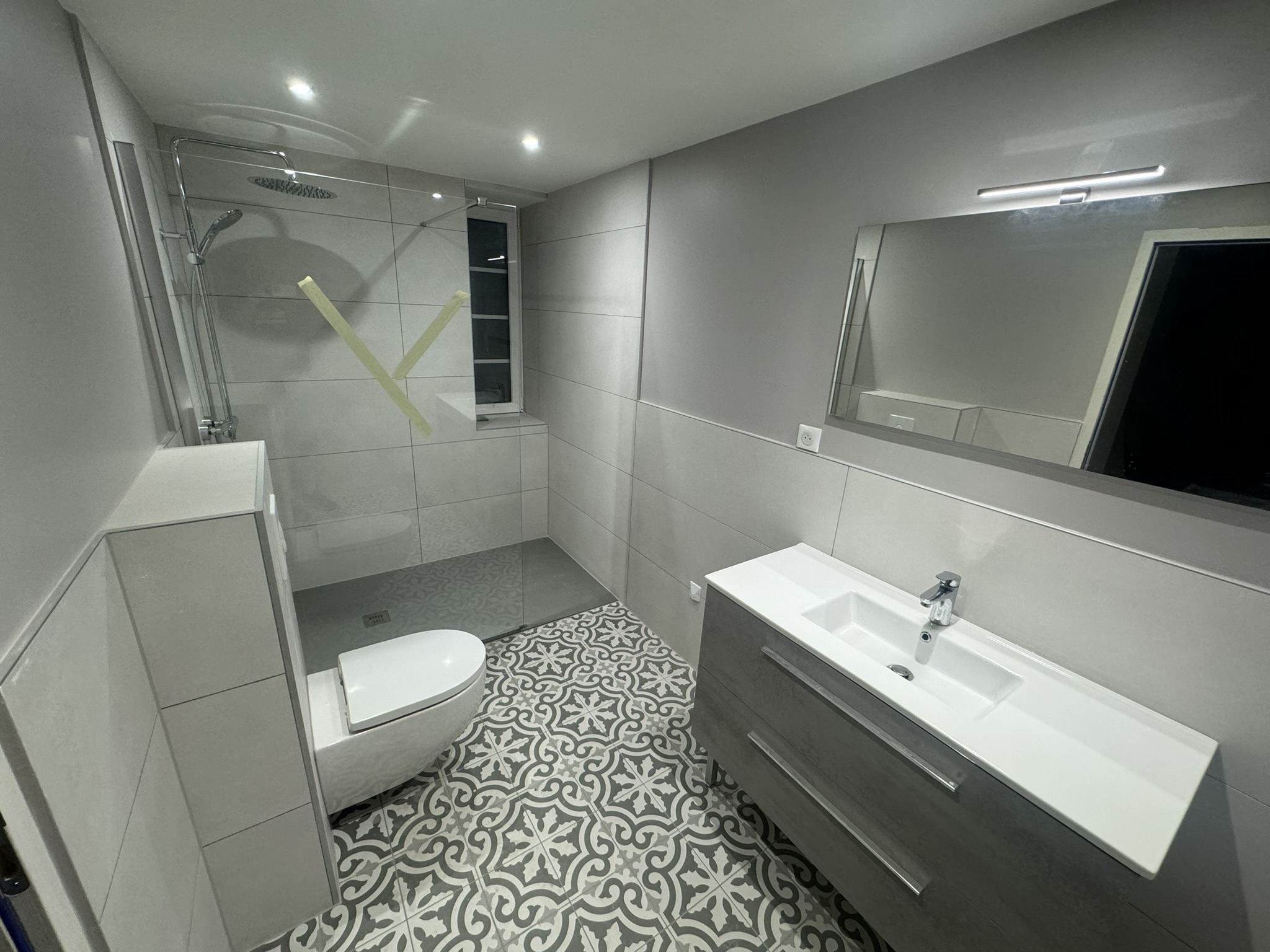 Baño moderno con ducha italiana y suelo hidráulico decorativo