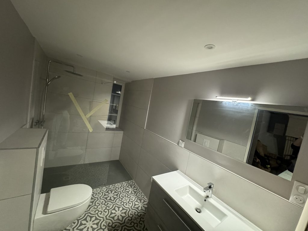 Baño moderno con ducha italiana, suelo hidráulico y espejo iluminado