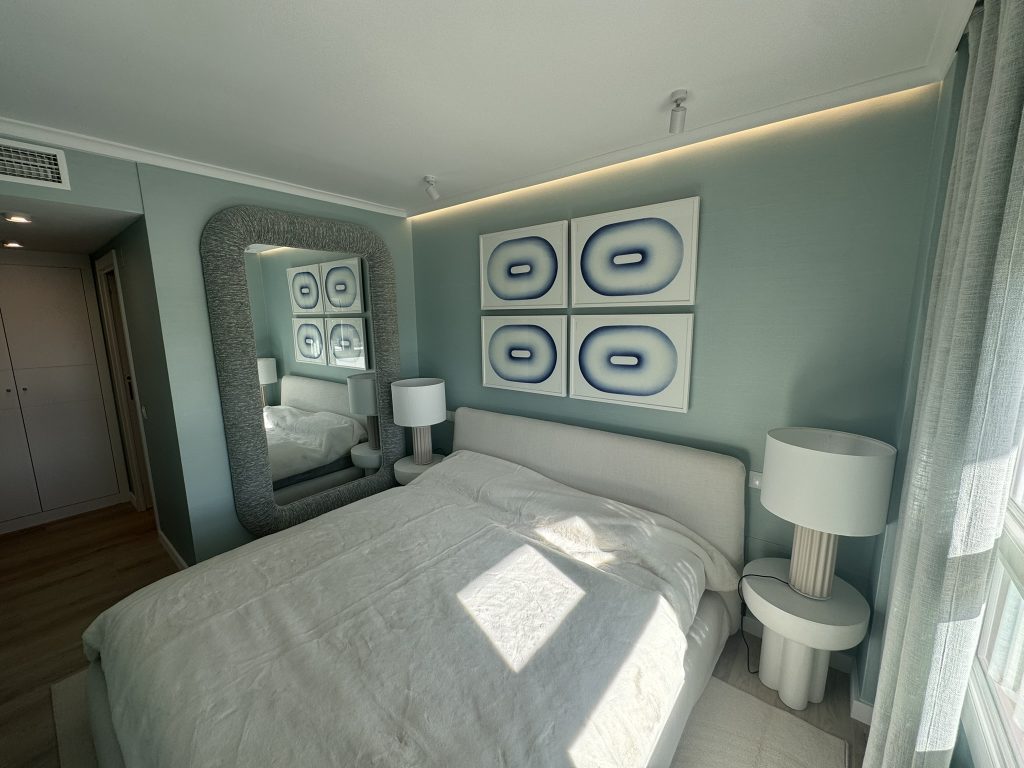 Dormitorio principal moderno con cama tapizada y decoración en tonos azules