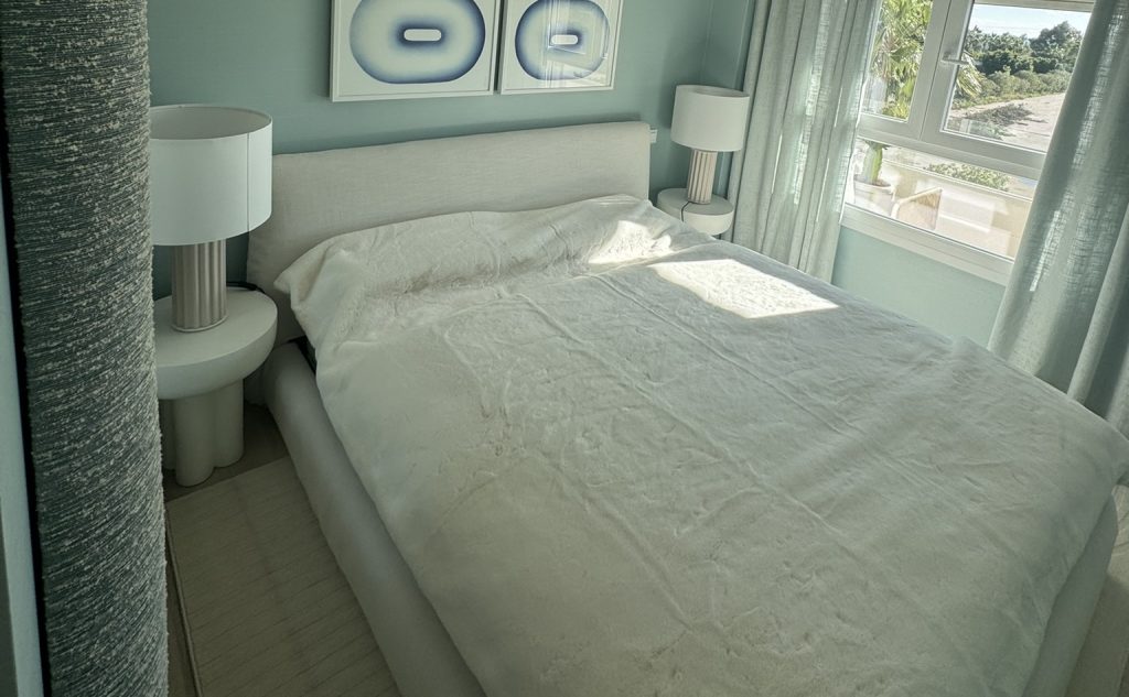 Dormitorio principal moderno con cama tapizada y decoración en azul y blanco
