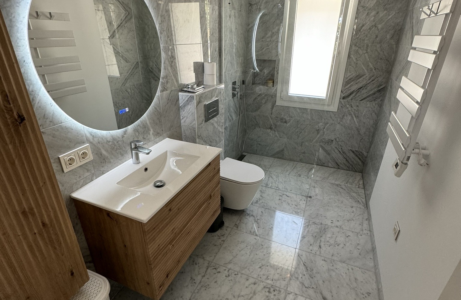 Baño moderno con mármol gris y mueble de madera